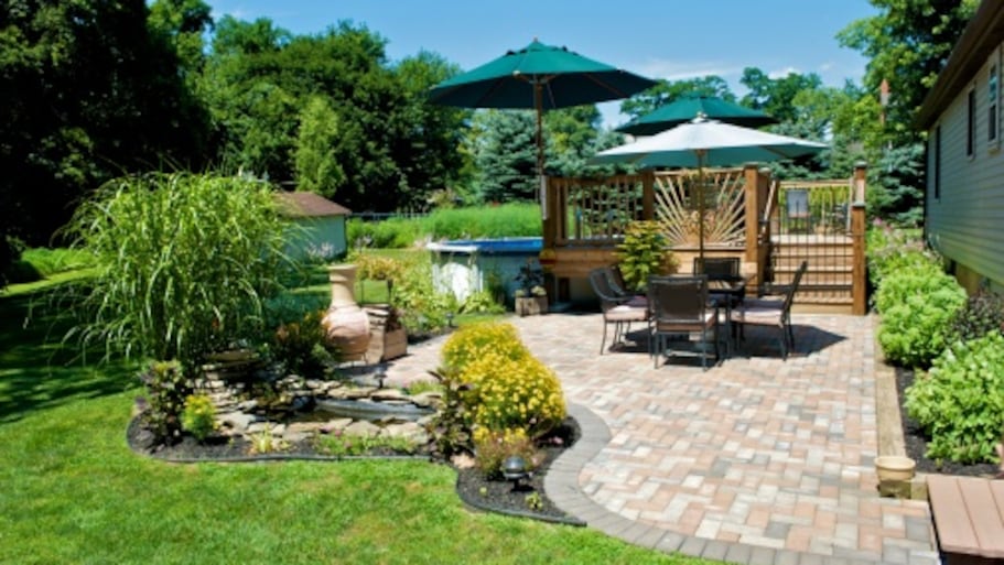 Sunny backyard with brick patio and a pond