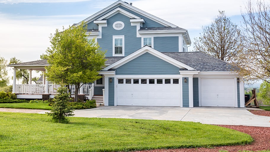 A blue house with a well-manicured lawn