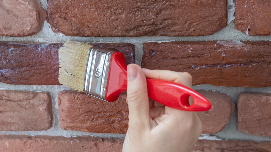 staining and sealing a brick wall with a paintbrush