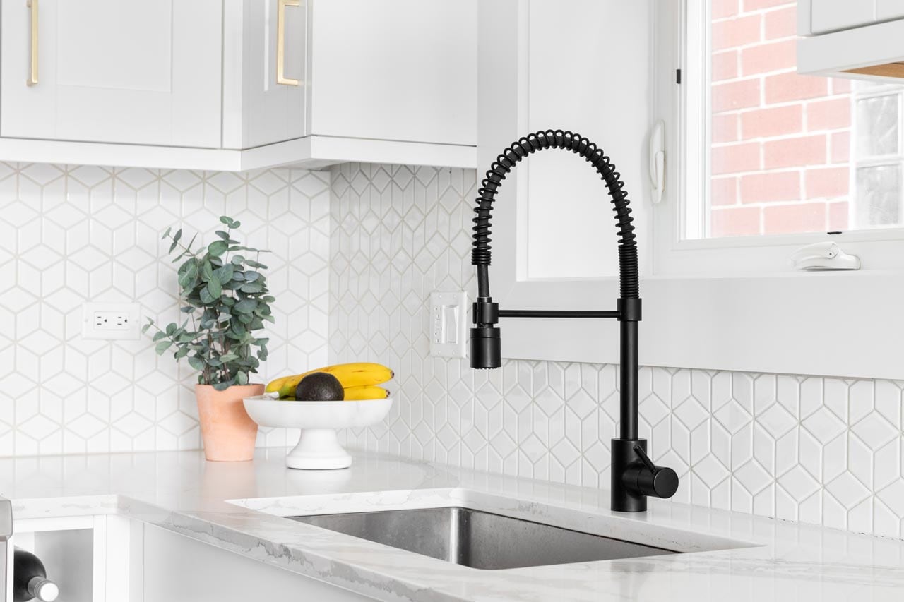 A bright kitchen with mosaic tiles used as a backsplash