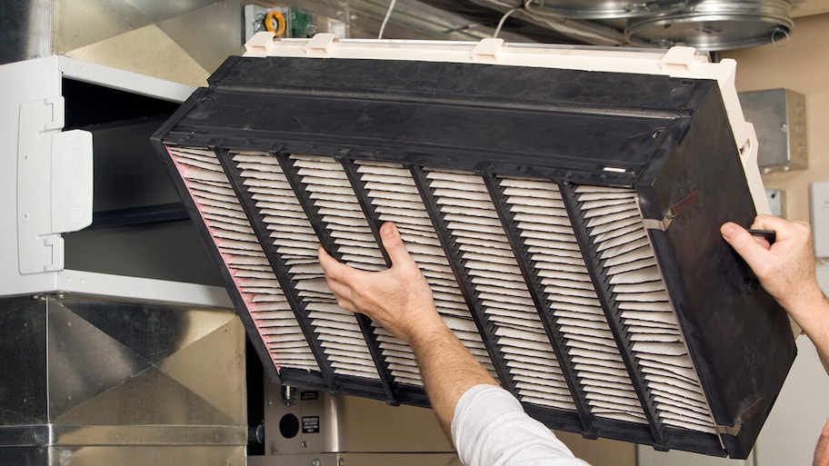 professional installing a central air cleaner filter