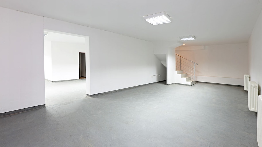 Empty basement with new concrete floor and white walls