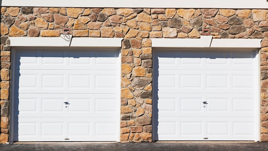 stone home with double garage doors