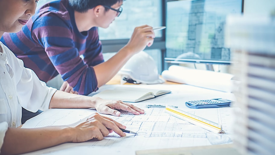 draftsperson working on house plans in an office