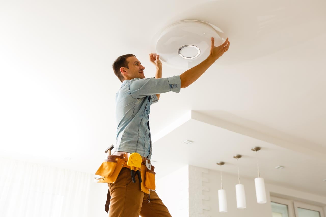 Electrician installing and connecting a lamp