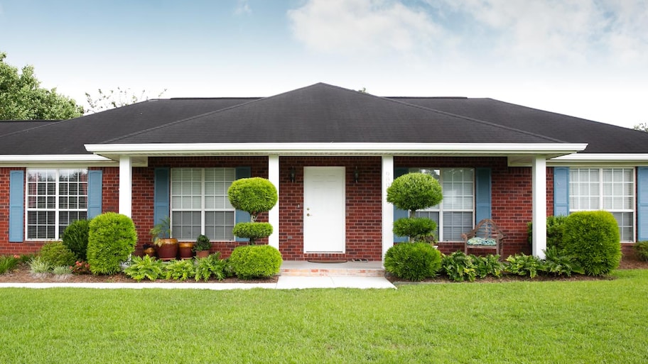 An exposed brick ranch house in the suburbs