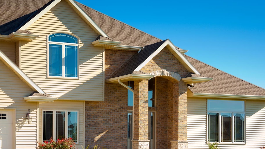 The exterior of a brick house with vinyl siding