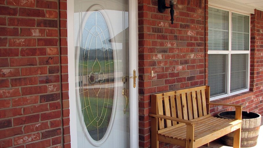 brick home with storm door on front entrance