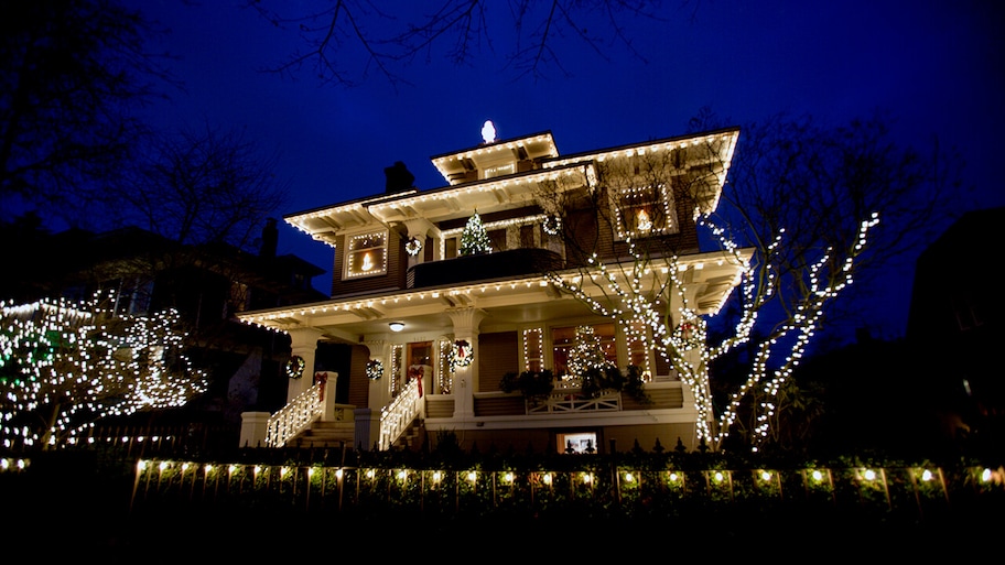 Home at night with holiday lights on house and trees