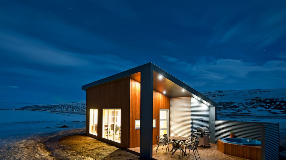 An illuminated metal house at night