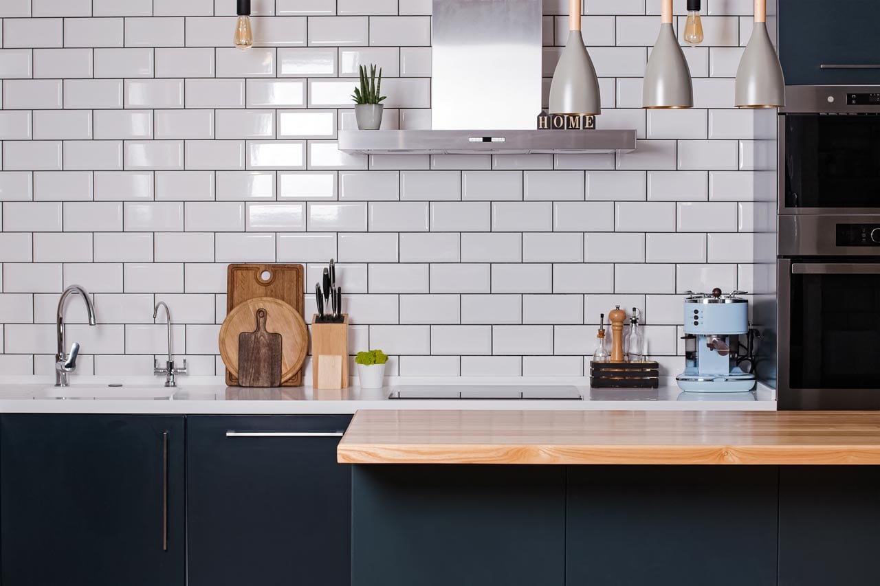 A kitchen with white glazed subway tiles