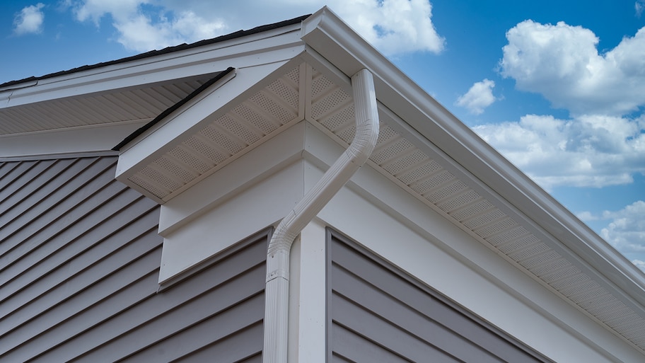 new gutters and downspouts installed on roof of house