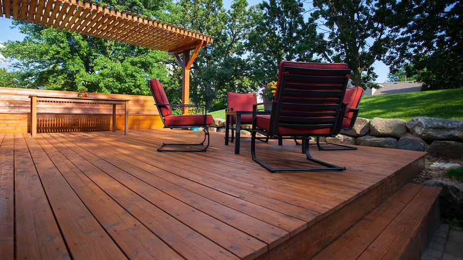 wooden deck in backyard with pergola and patio furniture