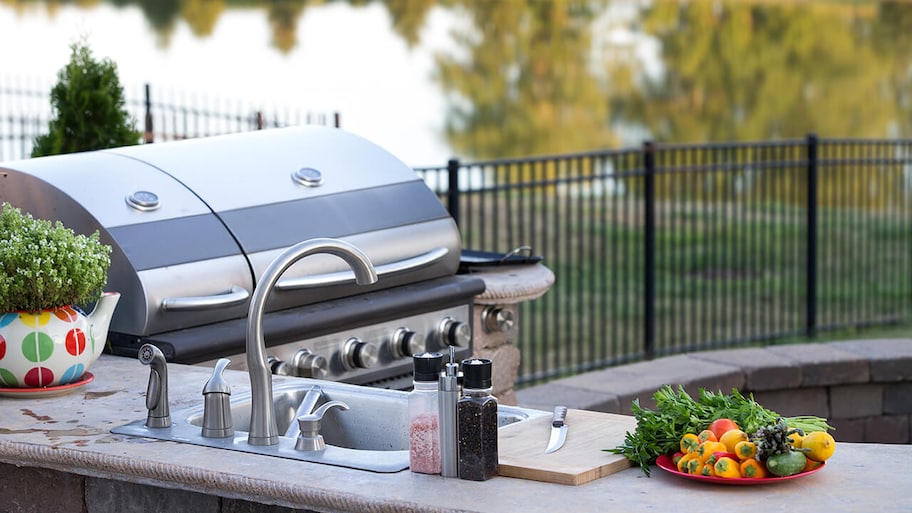 built-in outdoor kitchen with grill and sink