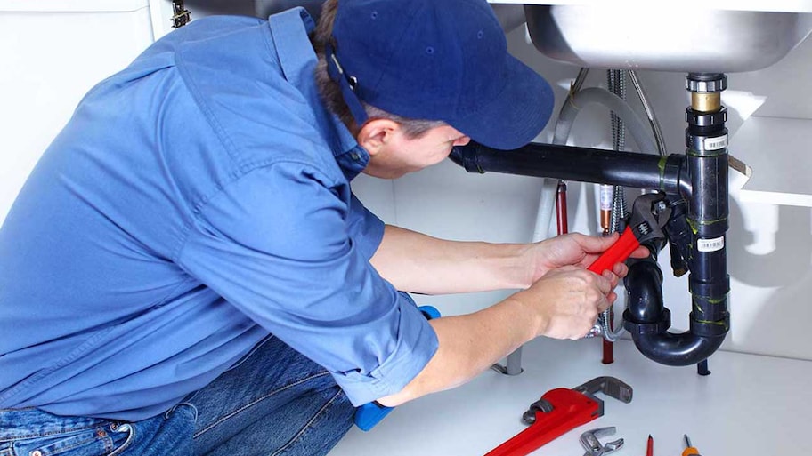 Plumber fixing bathroom sink pipes