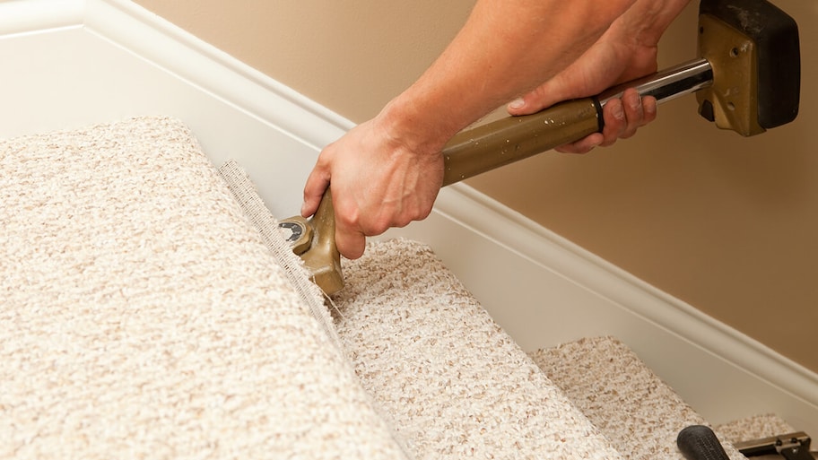 professional installing berber carpet on staircase in home