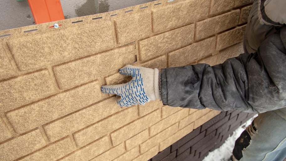 professional installing brick siding on exterior of home