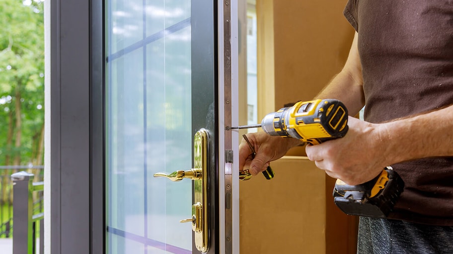 front door being installed on home with power tools