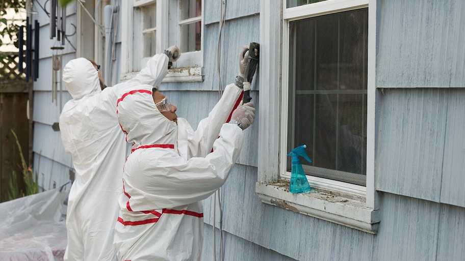 professionals in protective suits removing toxic lead from home exterior