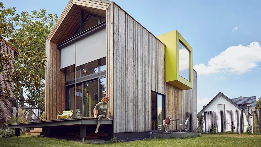 Mother and daughter sitting outside modern home