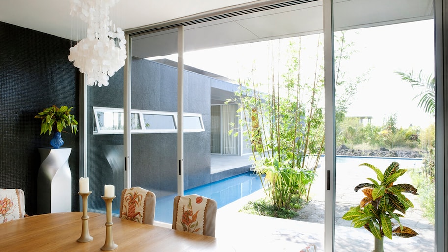 sliding glass door between dining room and swimming pool outside