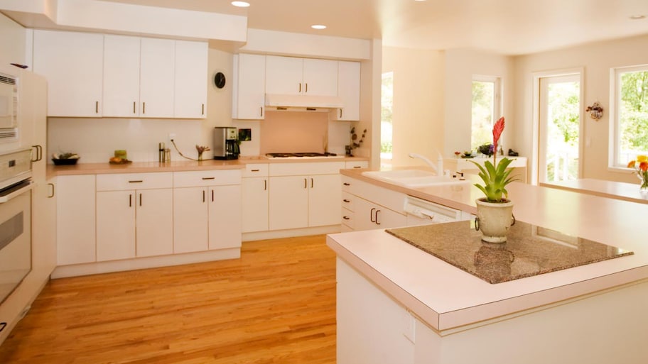 A spacious modern kitchen with laminate countertop and lots of natural sunlight