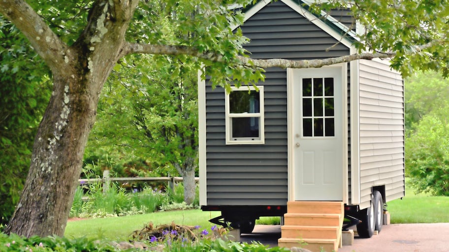 A tiny gray house on wheels