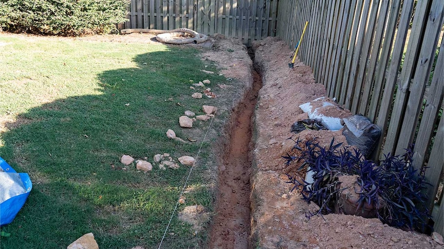 drainage system being installed in trench in yard