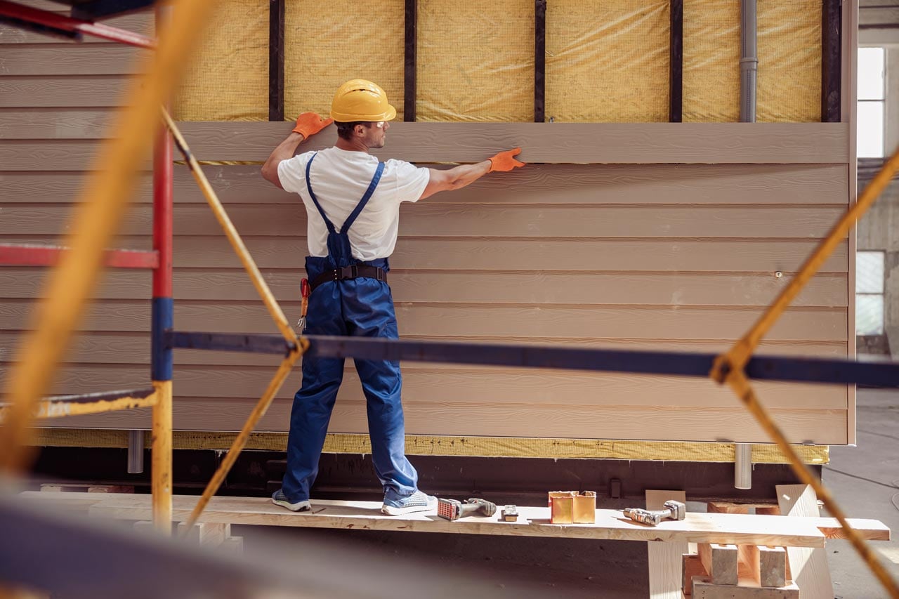 A worker building a cabin in a construction site