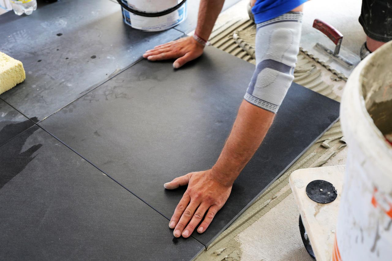 A worker laying new large format tiles