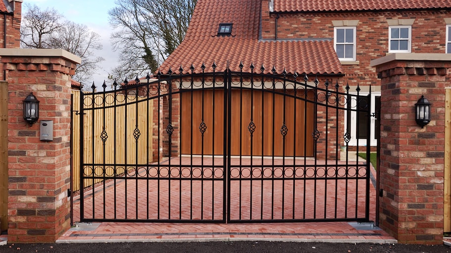 iron security gate at the end of driveway of home